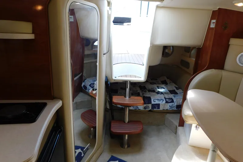 Slide: The Image of Interior of 2002 Rinker Fiesta Vee 310 boat, featuring cozy cabin and seating area. - 39