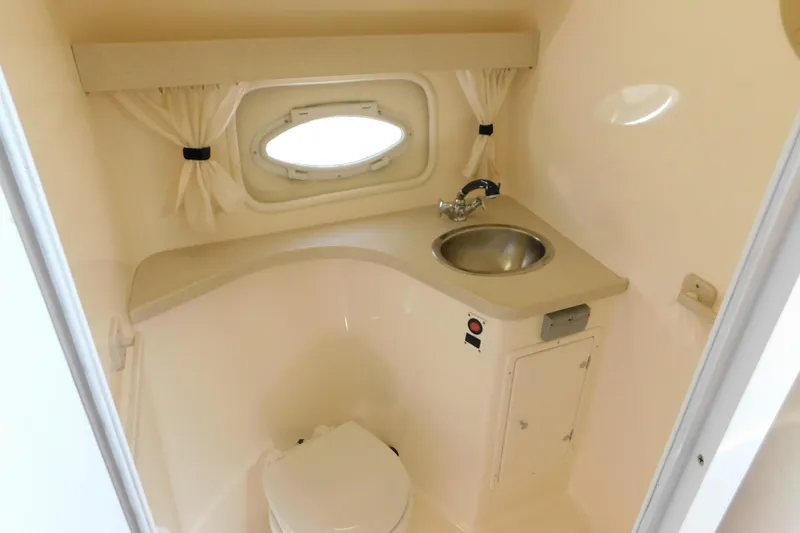 Slide: The Image of 2002 Rinker Fiesta Vee 310 boat bathroom with sink, toilet, and porthole window. - 41