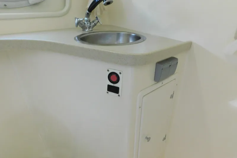 Slide: The Image of 2002 Rinker Fiesta Vee 310 boat interior with sink and storage compartment. - 42