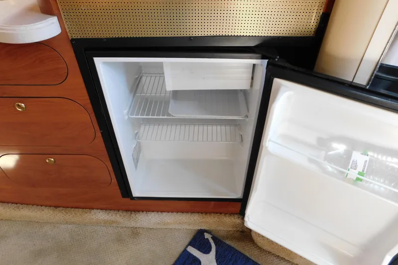 Slide: The Image of Open mini fridge inside a 2002 Rinker Fiesta Vee 310 boat cabin. - 48