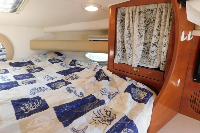 Slide: The Image of 2002 Rinker Fiesta Vee 310 cabin interior with bed and lace curtains. - 54