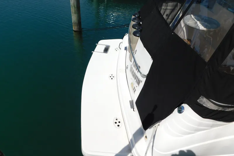 Slide: The Image of 2002 Rinker Fiesta Vee 310 boat docked, featuring a white deck and black canopy. - 6