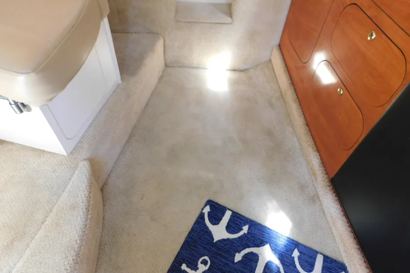 Slide: The Image of Interior of 2002 Rinker Fiesta Vee 310 with carpeted floor and wooden cabinetry. - 60
