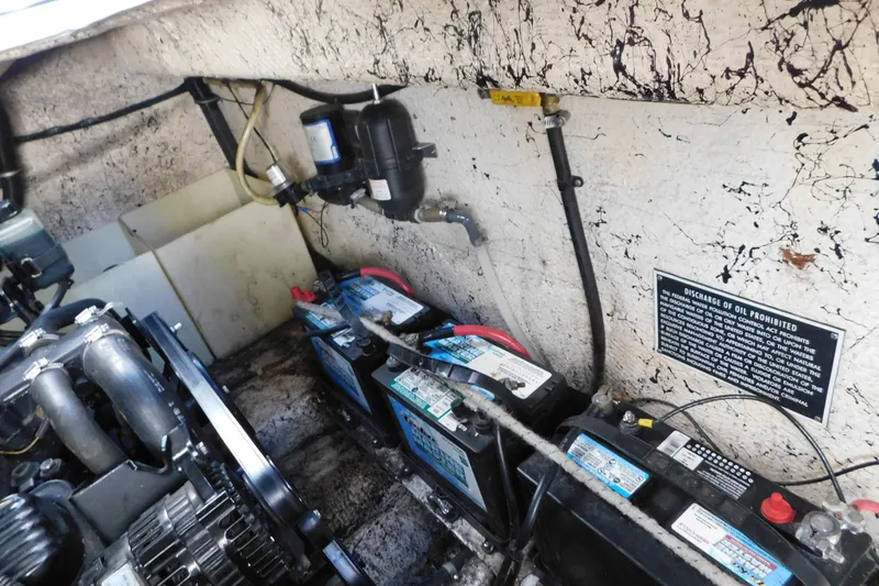 Slide: The Image of Engine compartment of 2002 Rinker Fiesta Vee 310 with batteries and discharge warning sign. - 67
