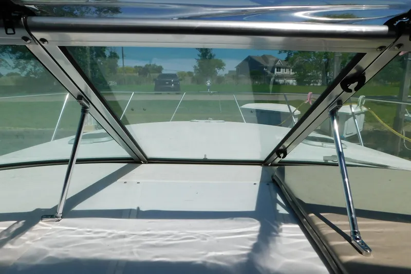 Slide: The Image of 2002 Rinker Fiesta Vee 310 boat windshield view, docked with clear skies and greenery. - 69