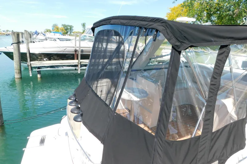 Slide: The Image of 2002 Rinker Fiesta Vee 310 boat docked with black canopy and clear windows. - 7