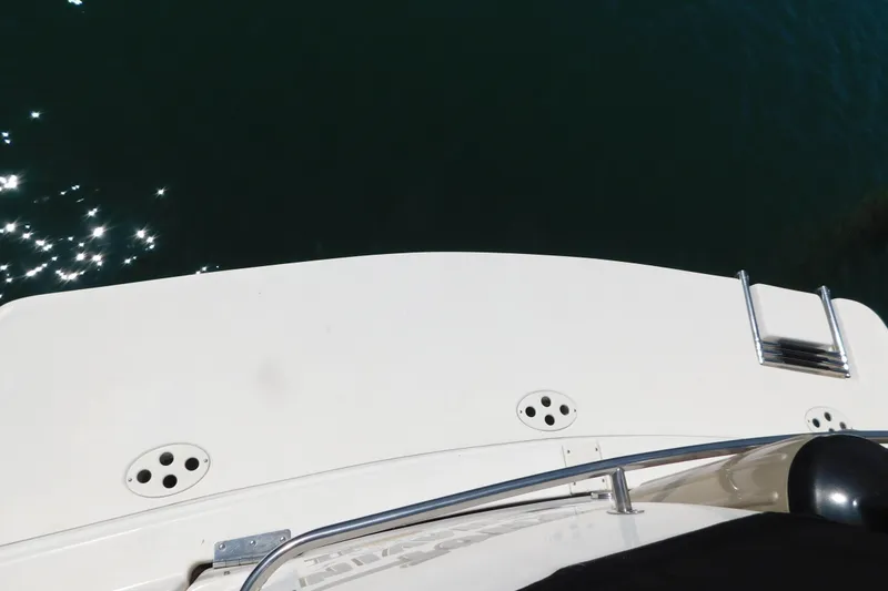 Slide: The Image of 2002 Rinker Fiesta Vee 310 boat deck with ladder, reflecting sunlight on water. - 71