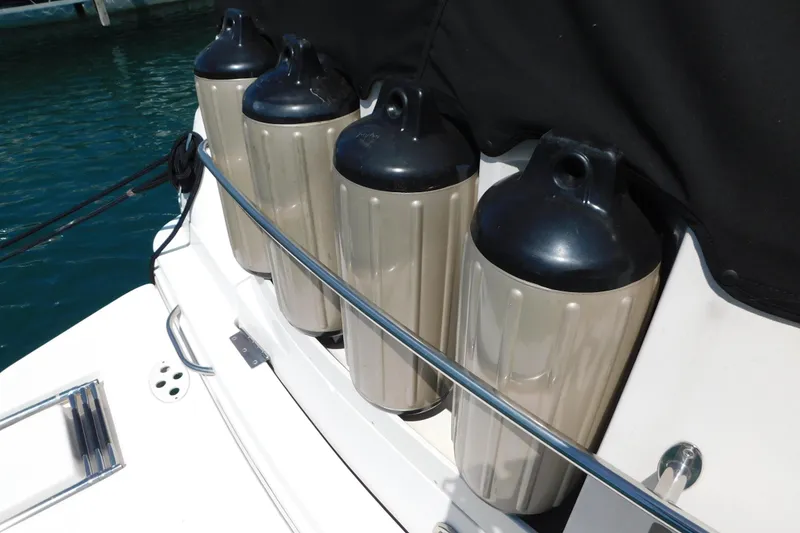 Slide: The Image of Boat fenders on a 2002 Rinker Fiesta Vee 310, docked by the water. - 72
