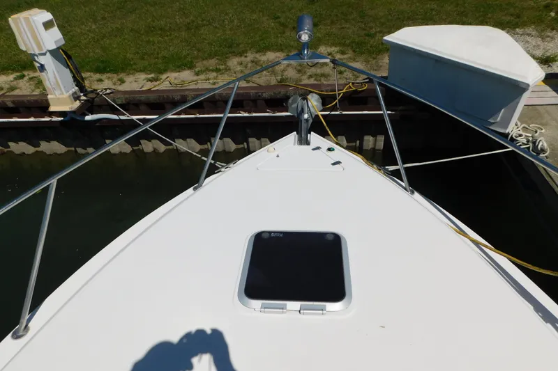 Slide: The Image of 2002 Rinker Fiesta Vee 310 boat docked, showing bow and deck details. - 75