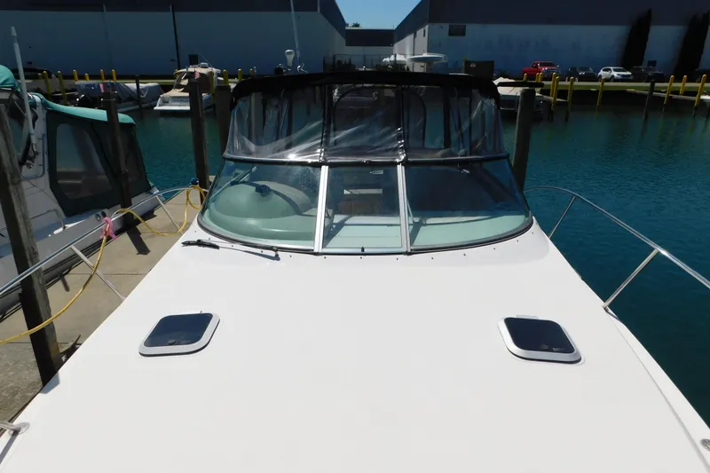 Slide: The Image of 2002 Rinker Fiesta Vee 310 docked at marina, featuring sleek design and spacious deck. - 78