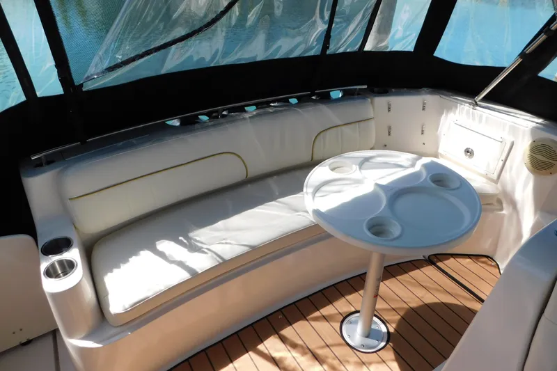 Slide: The Image of 2002 Rinker Fiesta Vee 310 boat interior with cushioned seating and round table. - 8