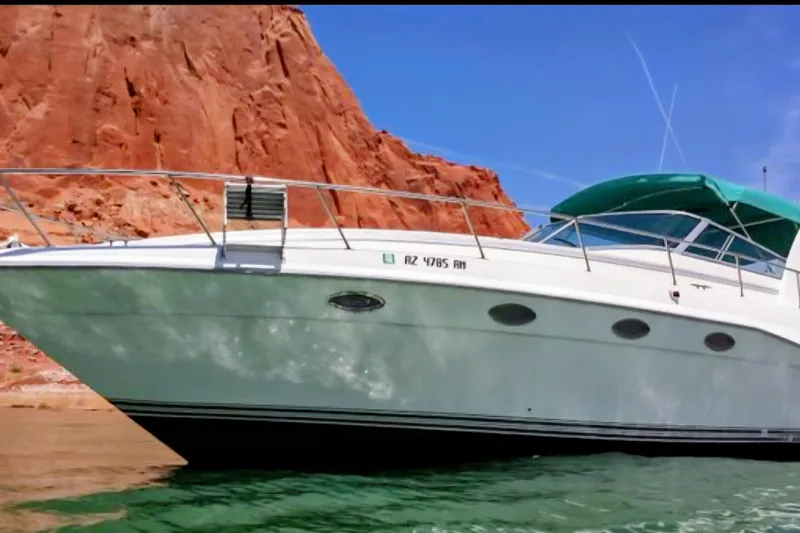 The Image of 1994 Cruisers Yachts 3675 Esprit on water, red rock backdrop, green canopy. - 0