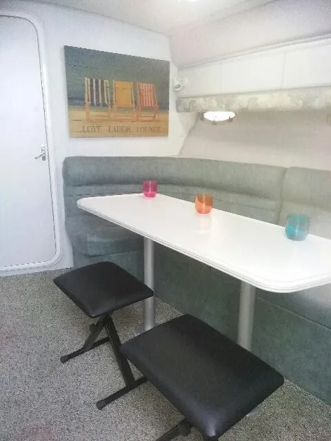 Slide: The Image of 1994 Cruisers Yachts 3672 Express interior with green sofa and decorative pillows. - 14