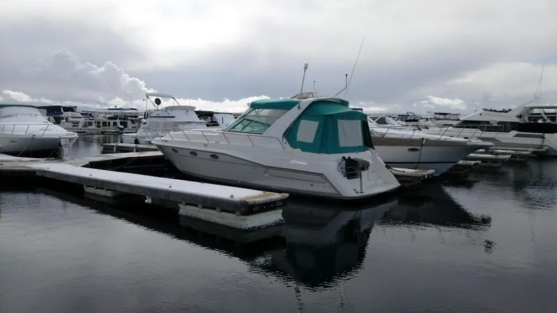 Slide: The Image of 1994 Cruisers Yachts 3672 Express docked at marina with blue lights reflecting on water. - 19