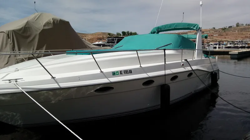 Slide: The Image of 1994 Cruisers Yachts 3672 Express boat docked with teal covers. - 2