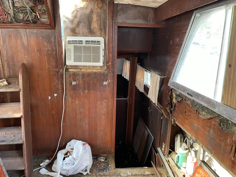 Slide: The Image of Interior of a 1964 Hatteras Double Cabin boat with wooden walls and an air conditioner. - 3