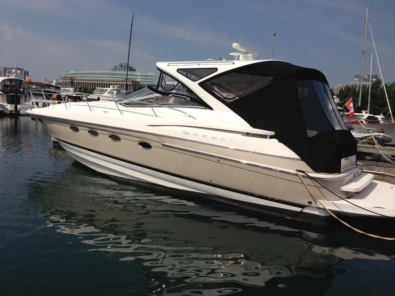 Slide: The Image of 2008 Regal Commodore 4460 yacht docked in marina, featuring sleek design and black canopy. - 0