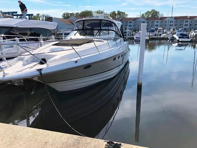 Slide: The Image of 2008 Regal Commodore 4460 yacht docked in a marina, reflecting on calm water. - 1