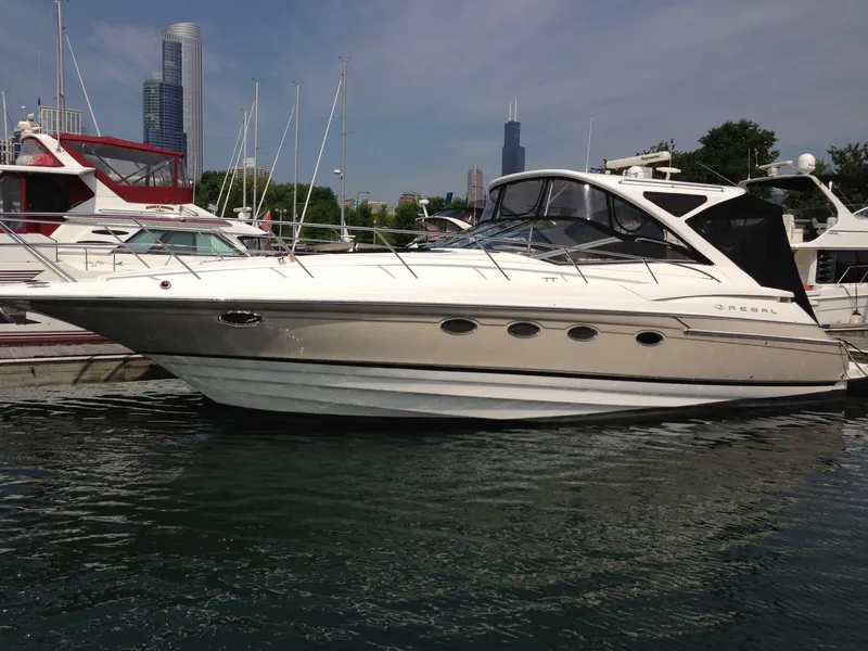 Slide: The Image of 2008 Regal Commodore 4460 yacht docked in marina, city skyline in background. - 2