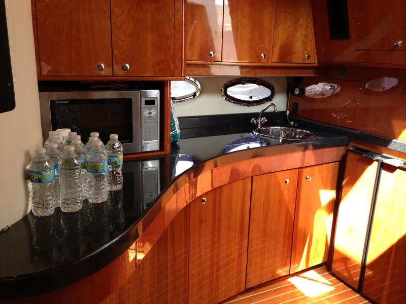 Slide: The Image of Luxurious 2008 Regal Commodore 4460 yacht kitchen with wood cabinetry and modern amenities. - 22