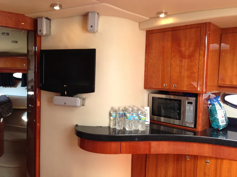 Slide: The Image of Interior of 2008 Regal Commodore 4460 yacht with TV, microwave, and wooden cabinetry. - 23