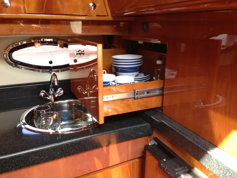 Slide: The Image of Luxurious 2008 Regal Commodore 4460 yacht kitchen with wooden cabinets and modern sink. - 27