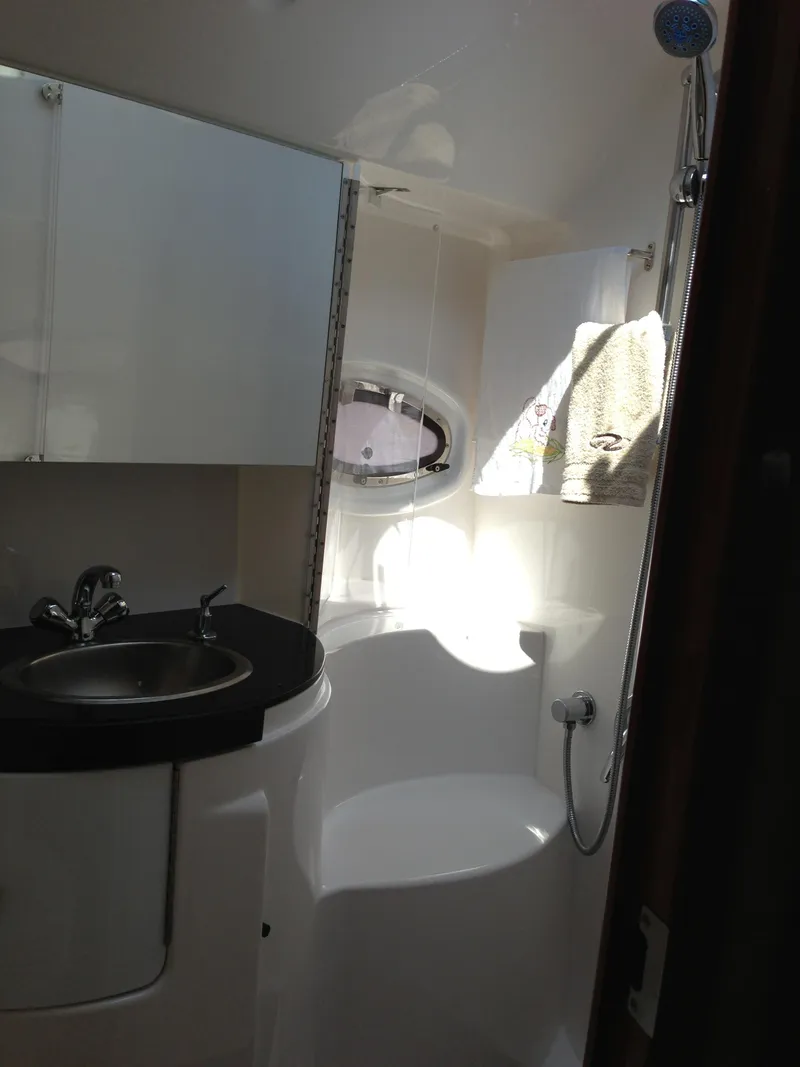 Slide: The Image of 2008 Regal Commodore 4460 yacht bathroom with sink, shower, and porthole window. - 31