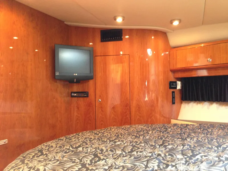 Slide: The Image of Luxurious 2008 Regal Commodore 4460 yacht interior with wood paneling and mounted TV. - 32
