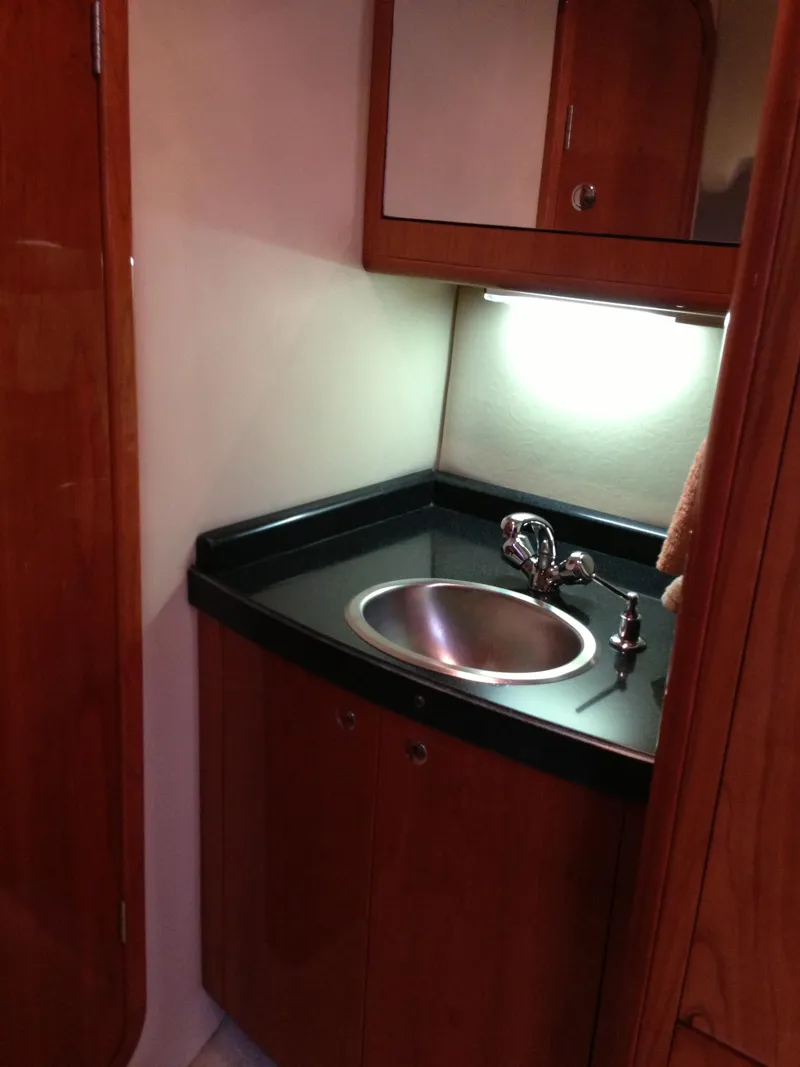Slide: The Image of 2008 Regal Commodore 4460 yacht bathroom with wooden cabinetry and stainless steel sink. - 34