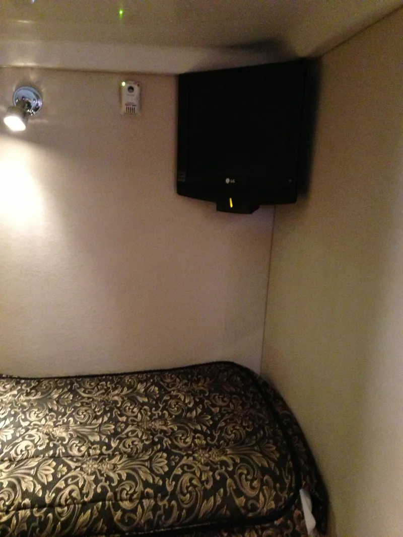 Slide: The Image of 2008 Regal Commodore 4460 cabin interior with patterned bedding and wall-mounted TV. - 39