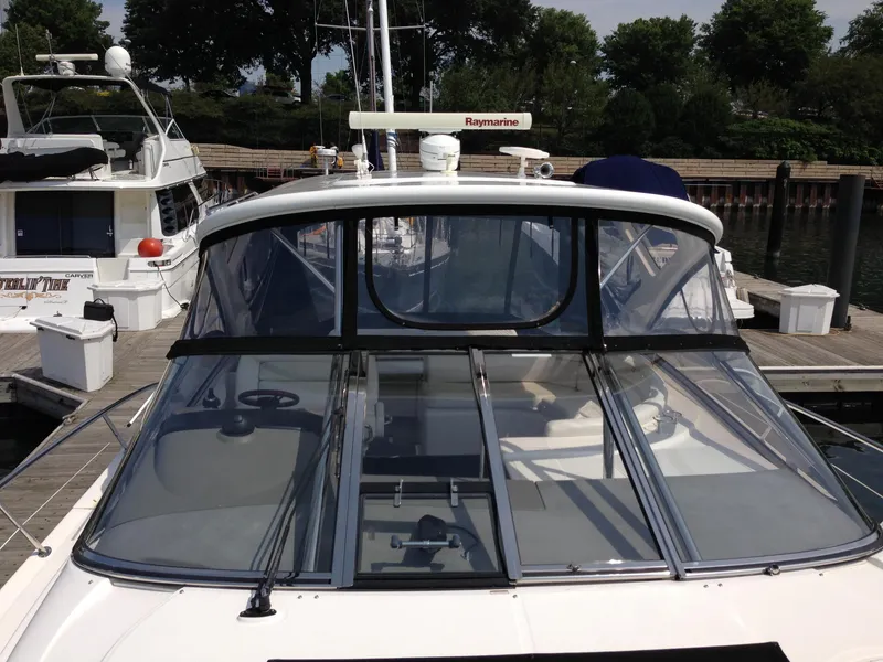 Slide: The Image of 2008 Regal Commodore 4460 yacht docked, featuring sleek design and clear cockpit enclosure. - 4