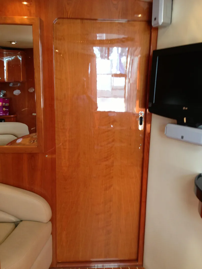 Slide: The Image of Interior of 2008 Regal Commodore 4460 yacht with wooden door and mounted TV. - 40
