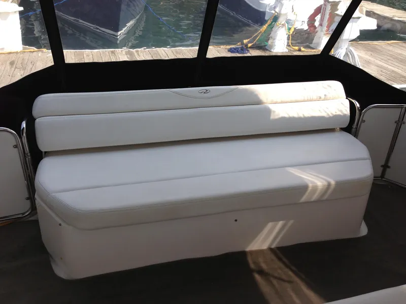 Slide: The Image of White seating on 2008 Regal Commodore 4460 boat, docked with visible water and ropes. - 8