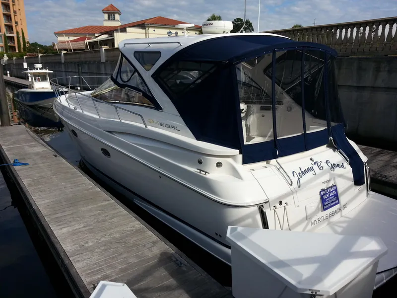 Slide: The Image of 2007 Regal Commodore 4060 yacht docked at marina with blue canopy. - 10