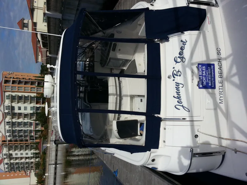 Slide: The Image of 2007 Regal Commodore 4060 yacht docked, featuring blue canopy and "Johnny B. Good" name. - 11