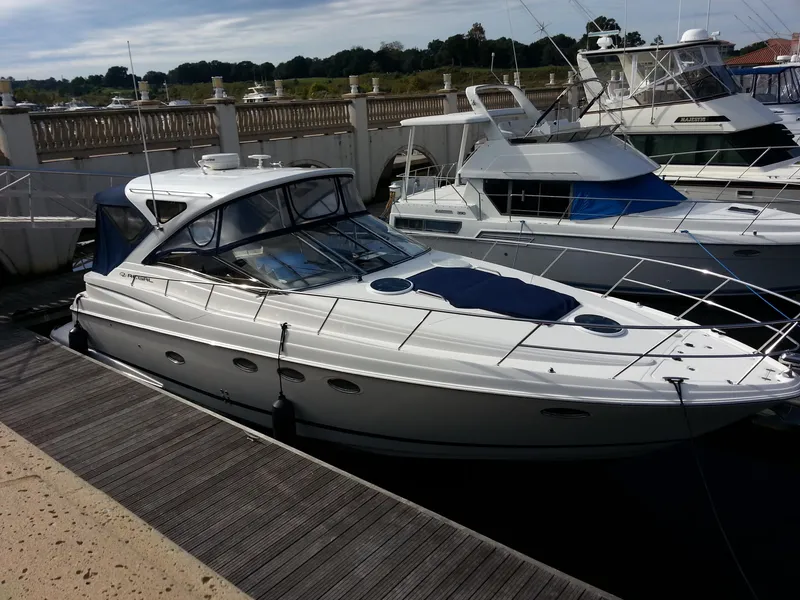 Slide: The Image of 2007 Regal Commodore 4060 yacht docked at marina, sleek design, white exterior. - 13