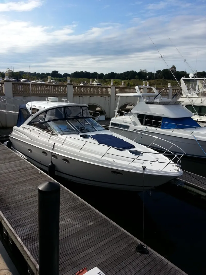 Slide: The Image of 2007 Regal Commodore 4060 yacht docked at a marina under a partly cloudy sky. - 14