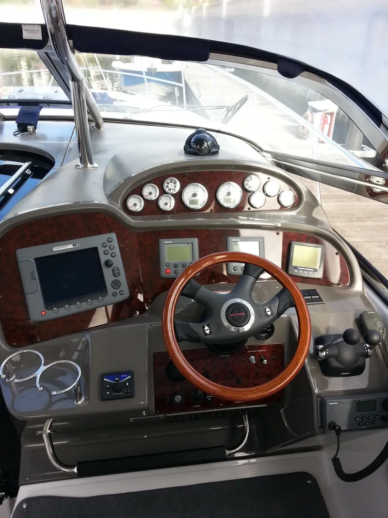 Slide: The Image of 2007 Regal Commodore 4060 helm with wood accents and modern navigation instruments. - 16