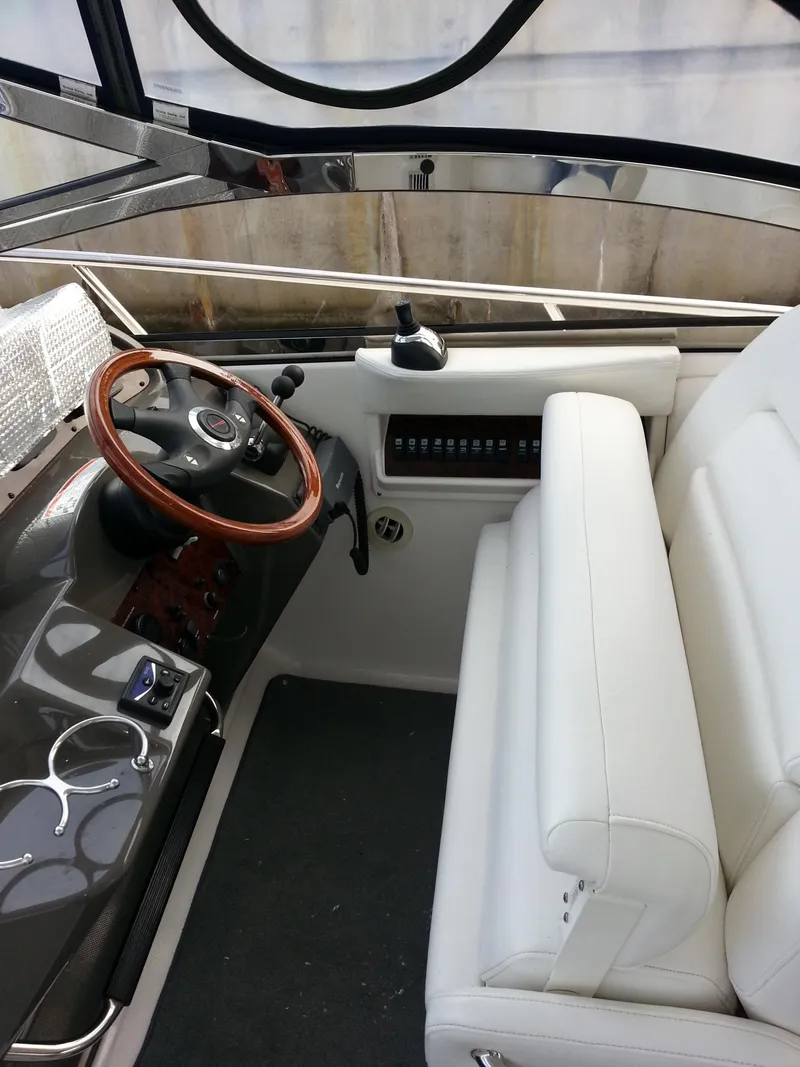 Slide: The Image of 2007 Regal Commodore 4060 boat interior with white seating and wooden steering wheel. - 19