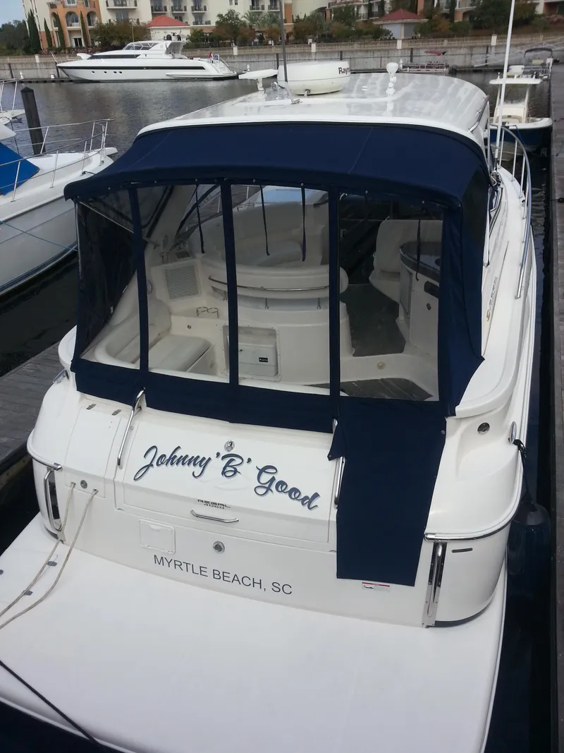 Slide: The Image of 2007 Regal Commodore 4060 yacht docked, featuring blue canopy and "Johnny 'B' Good" name. - 2