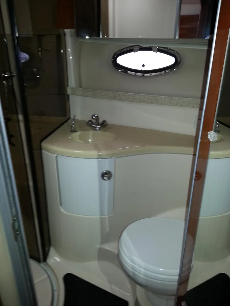 Slide: The Image of 2007 Regal Commodore 4060 yacht bathroom with sink, toilet, and porthole window. - 25