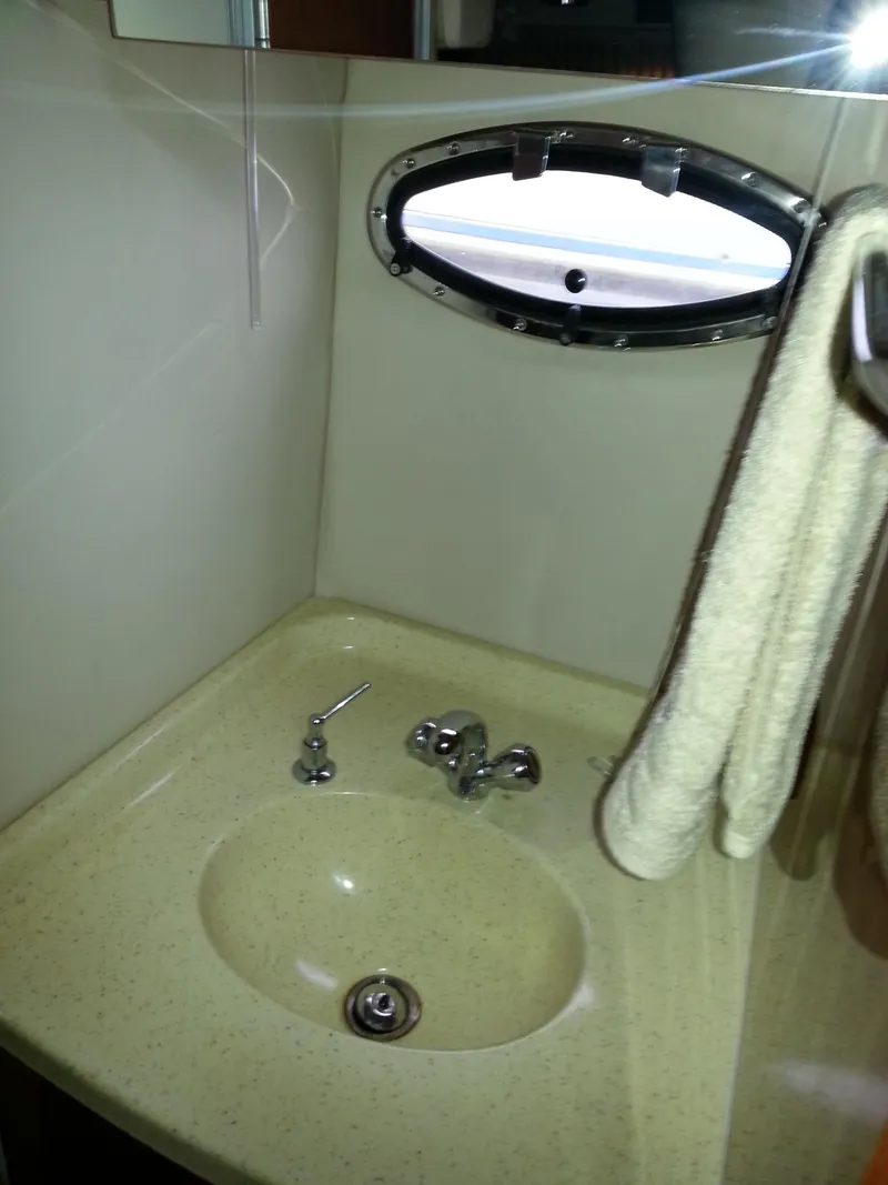 Slide: The Image of 2007 Regal Commodore 4060 bathroom sink with towel and porthole window. - 32