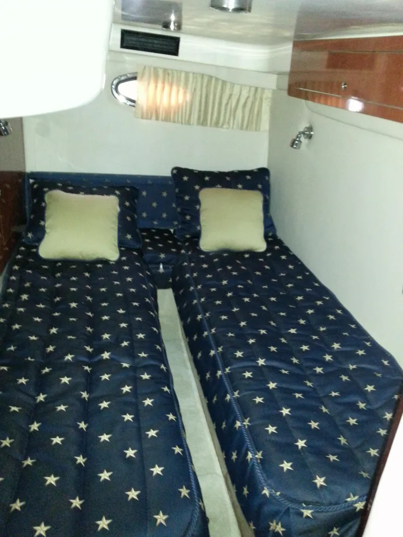 Slide: The Image of Twin beds with star-patterned bedding in 2007 Regal Commodore 4060 cabin. - 33
