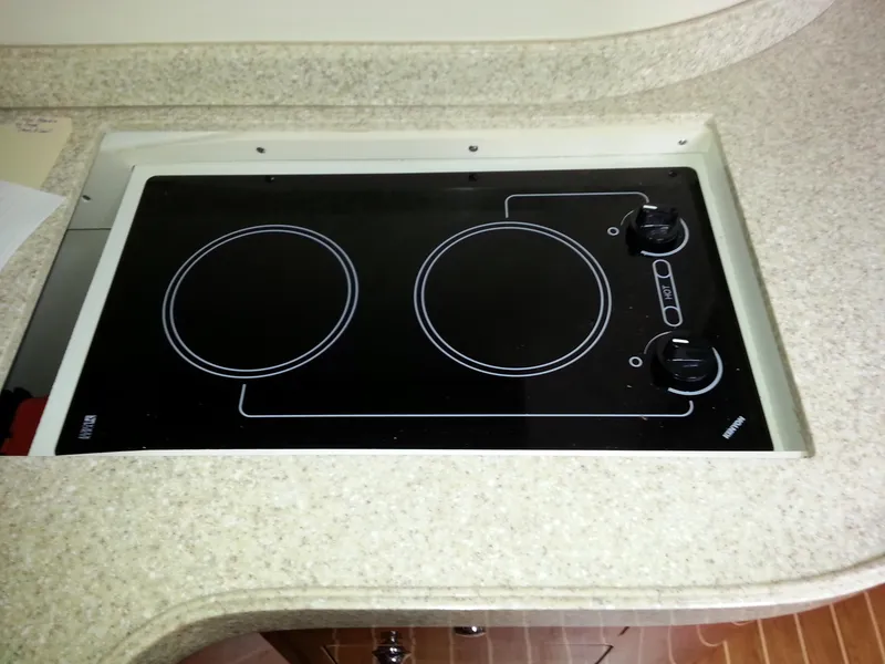 Slide: The Image of 2007 Regal Commodore 4060 stovetop with two burners on a beige countertop. - 37