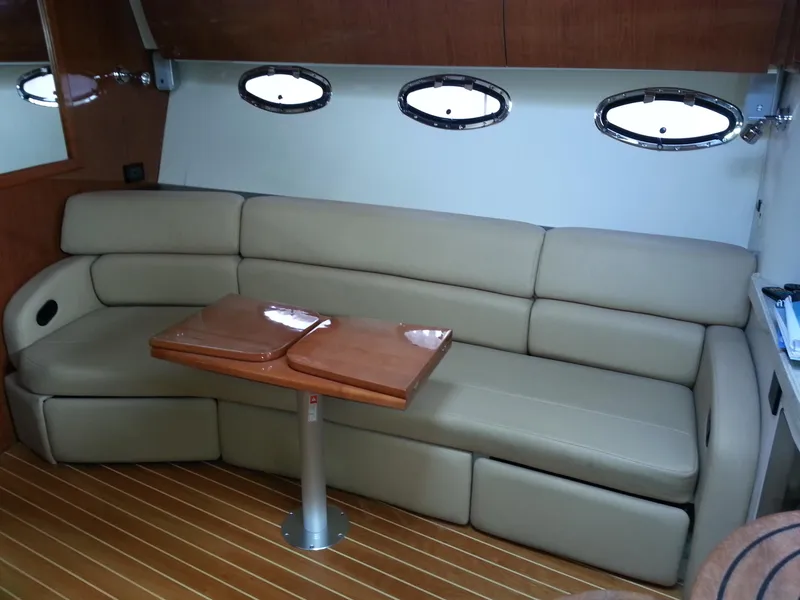 Slide: The Image of Luxurious interior of 2007 Regal Commodore 4060 yacht with beige seating and wooden table. - 38