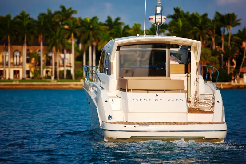 Slide: The Image of Luxury 2012 Prestige 440S yacht cruising near palm-lined waterfront homes. - 10