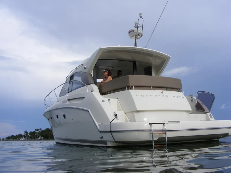 Slide: The Image of Luxury 2012 Prestige 440S yacht on calm water, rear view with ladder. - 11