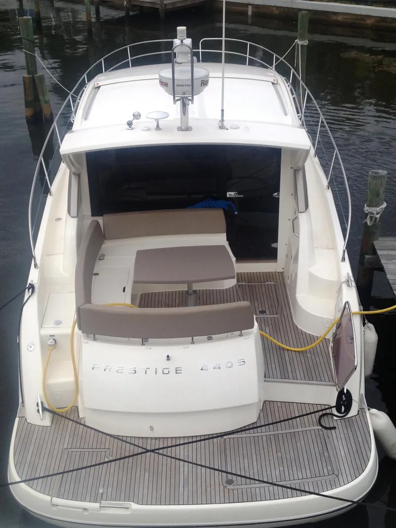 Slide: The Image of 2012 Prestige 440S yacht docked, featuring spacious deck and seating area. - 12