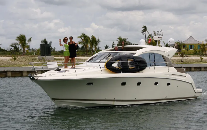 Slide: The Image of Prestige 440S yacht from 2012 cruising with passengers waving, tropical backdrop. - 18