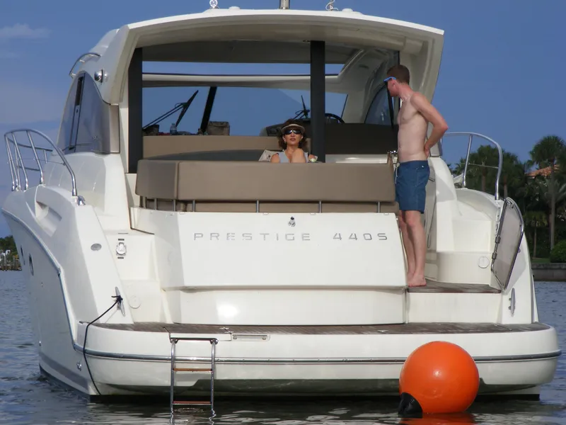 Slide: The Image of 2012 Prestige 440S yacht with people relaxing on deck, anchored near shore. - 22